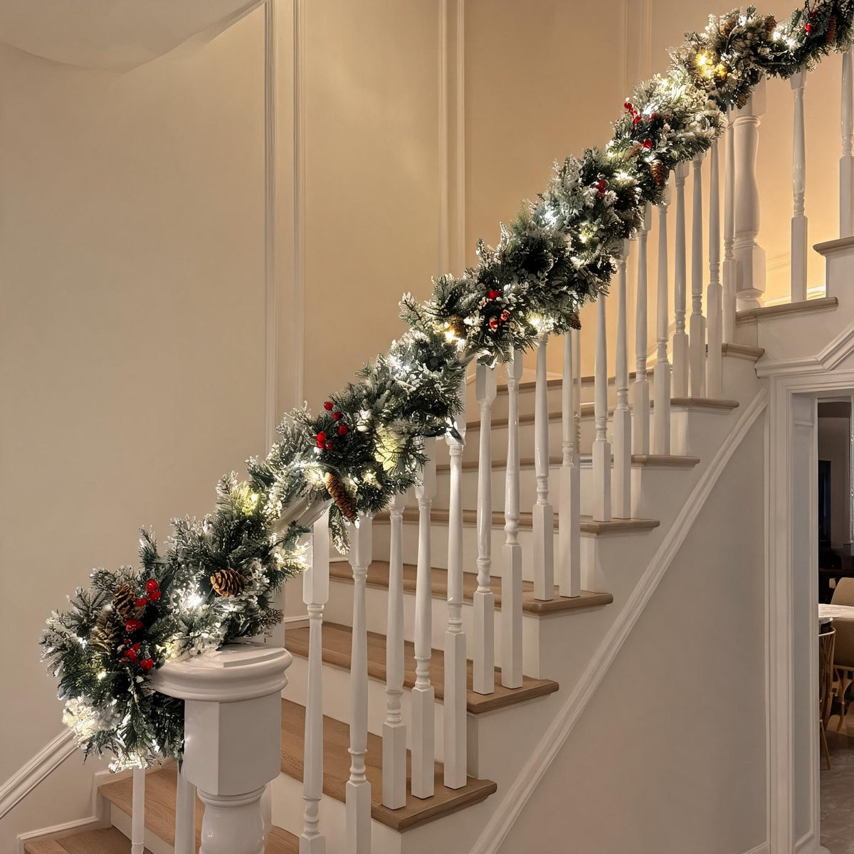 Pre-lit snow flocked Christmas garland on staircase